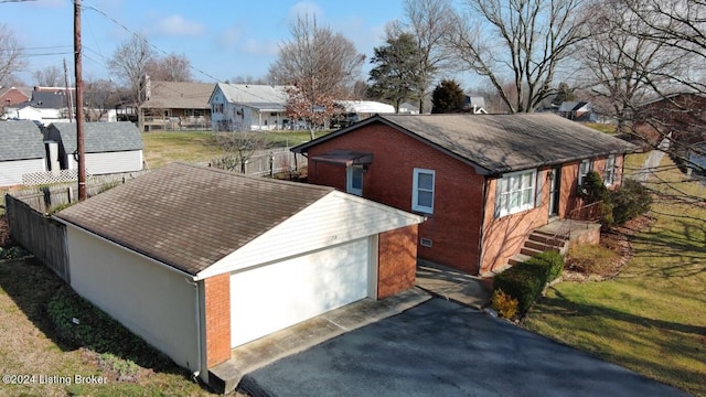 exterior space featuring fence, a yard, a residential view, a shingled roof, and brick siding