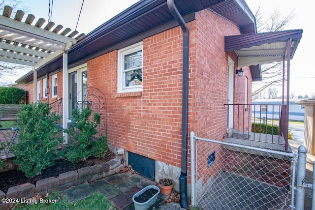 view of side of property featuring brick siding and fence