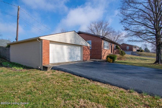 view of property exterior featuring a yard, brick siding, an outbuilding, and a garage