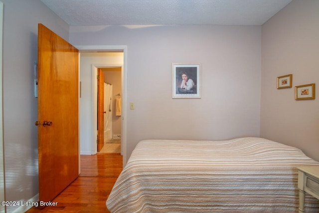 bedroom featuring a textured ceiling and wood finished floors