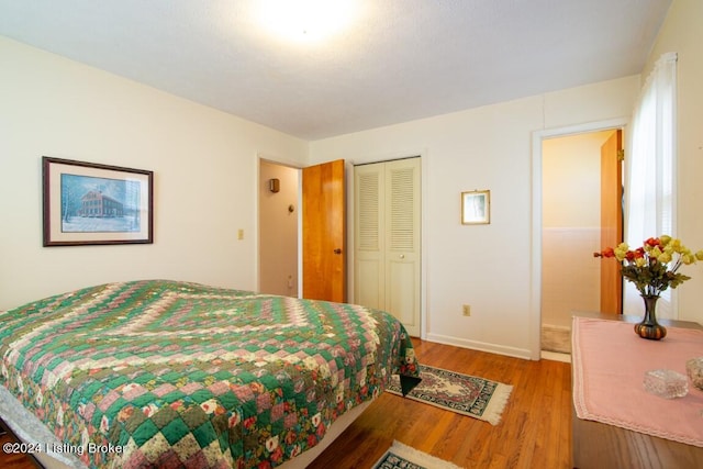 bedroom featuring wood finished floors, a closet, and baseboards