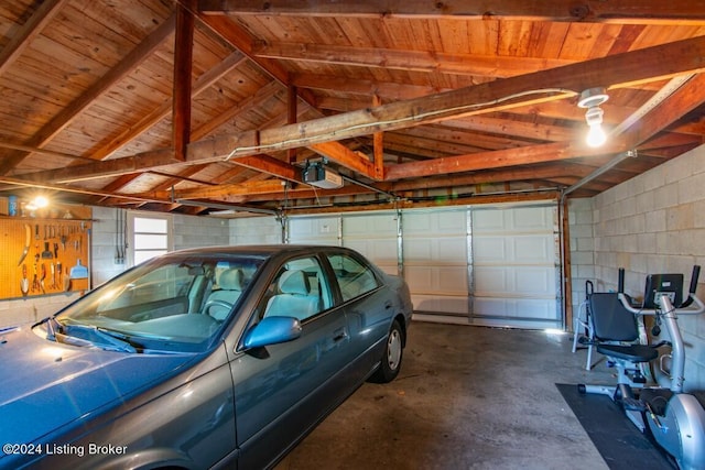 garage featuring concrete block wall and a garage door opener