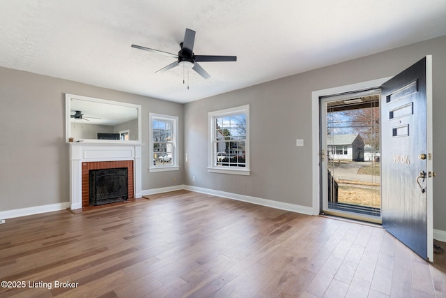 unfurnished living room with a healthy amount of sunlight, wood finished floors, and ceiling fan