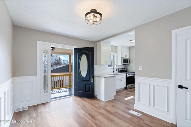 entrance foyer with visible vents, plenty of natural light, and light wood finished floors