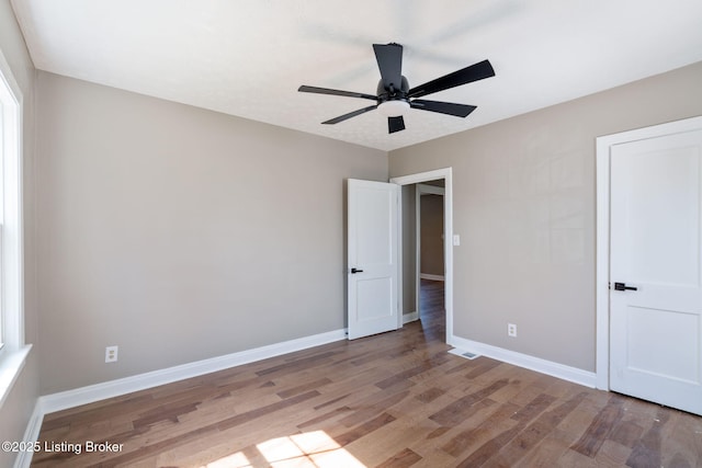 unfurnished bedroom featuring wood finished floors, baseboards, and ceiling fan