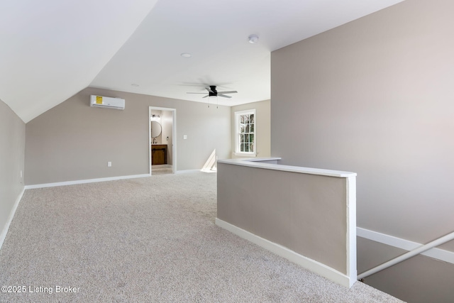 interior space featuring an upstairs landing, baseboards, a wall unit AC, and carpet floors