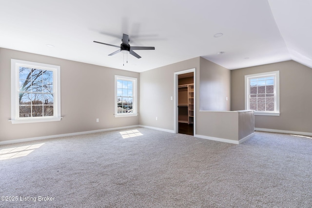 carpeted spare room with a wealth of natural light, baseboards, and ceiling fan