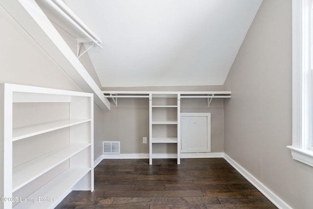 spacious closet featuring visible vents, lofted ceiling, and hardwood / wood-style flooring