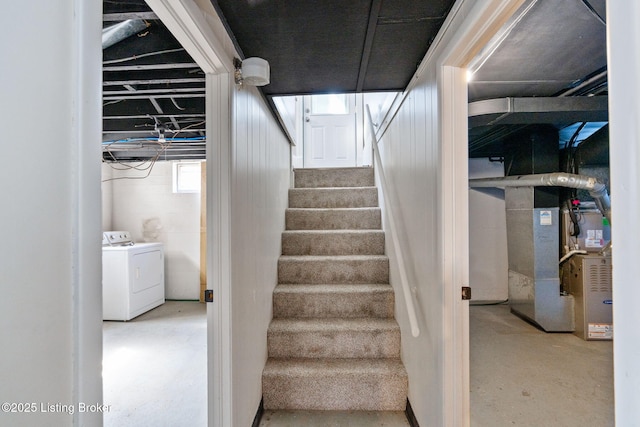 staircase with heating unit, concrete floors, and washing machine and clothes dryer