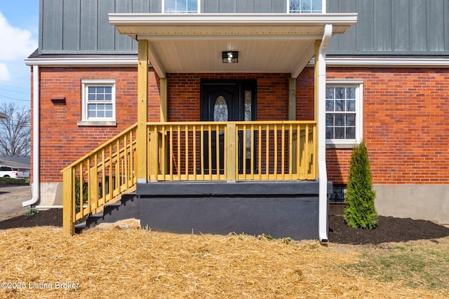 doorway to property featuring brick siding and board and batten siding