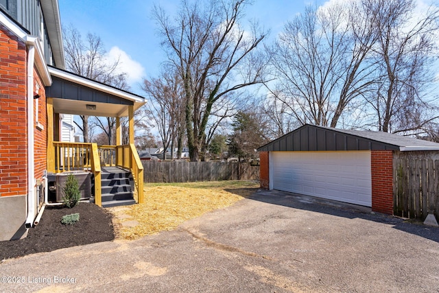 view of yard with central AC, a detached garage, an outdoor structure, and fence