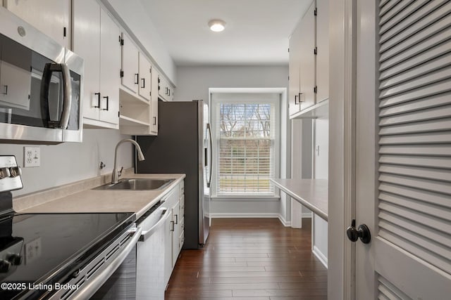 kitchen featuring dark wood finished floors, light countertops, white cabinets, stainless steel appliances, and a sink