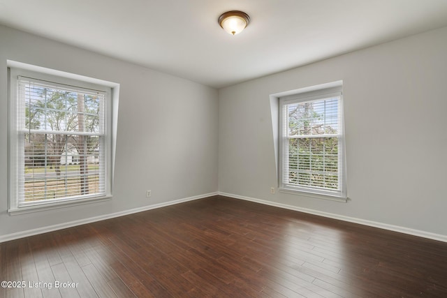 empty room with dark wood-style floors and baseboards