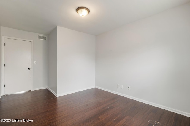 spare room featuring dark wood finished floors, baseboards, and visible vents