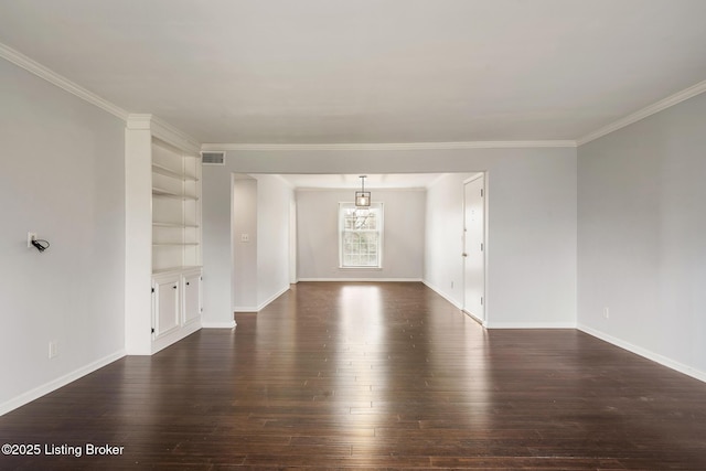 empty room featuring visible vents, built in shelves, dark wood-style floors, and crown molding