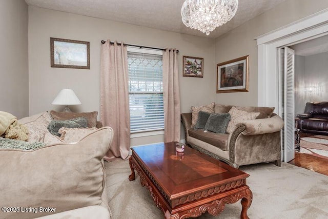 carpeted living room featuring an inviting chandelier and a textured ceiling