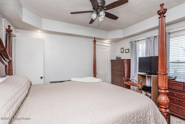 bedroom with ceiling fan and a textured ceiling