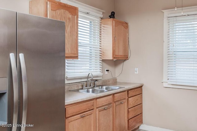 kitchen featuring a sink, light brown cabinetry, a wealth of natural light, and stainless steel refrigerator with ice dispenser