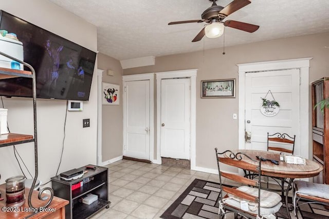 dining room featuring baseboards, a textured ceiling, and ceiling fan