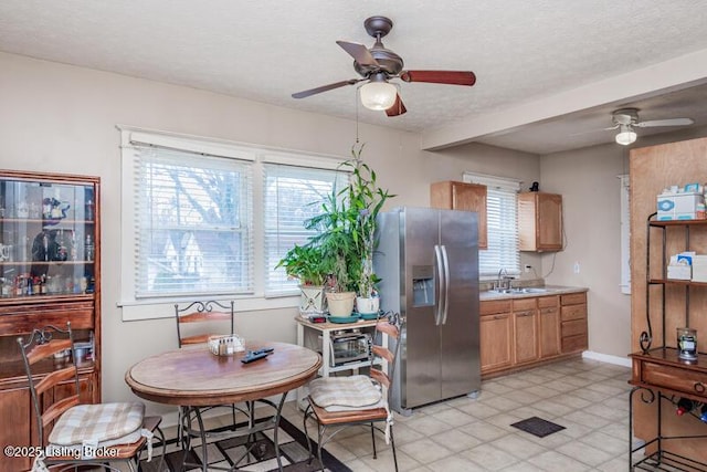 dining room featuring baseboards, plenty of natural light, a textured ceiling, and ceiling fan