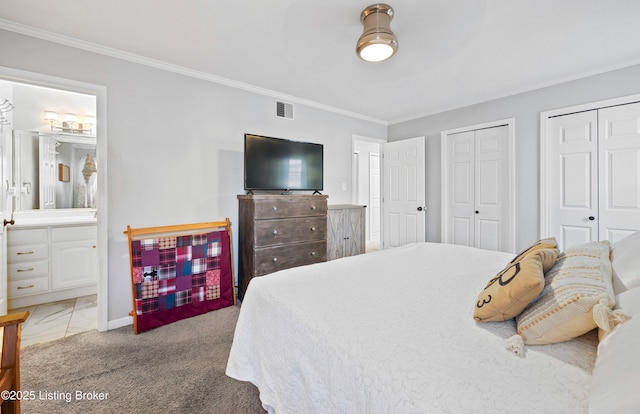 bedroom featuring visible vents, multiple closets, connected bathroom, crown molding, and baseboards