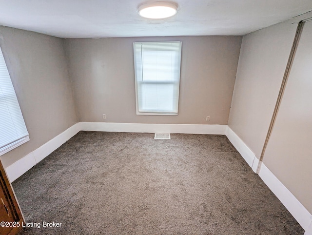 spare room featuring visible vents, baseboards, and carpet