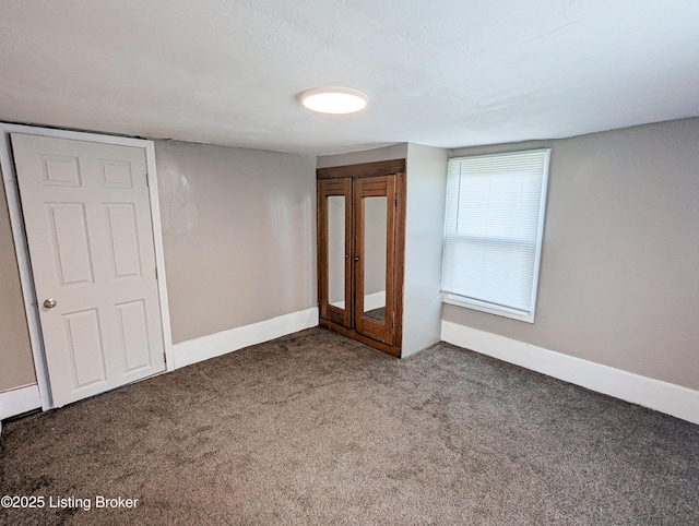 unfurnished bedroom featuring carpet flooring and baseboards