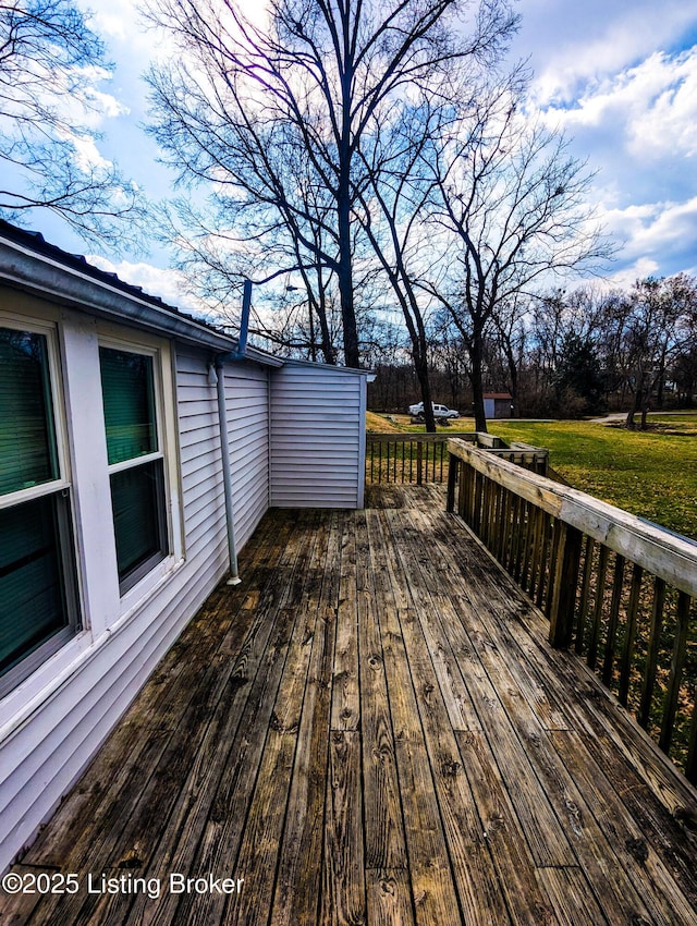 wooden terrace featuring a lawn