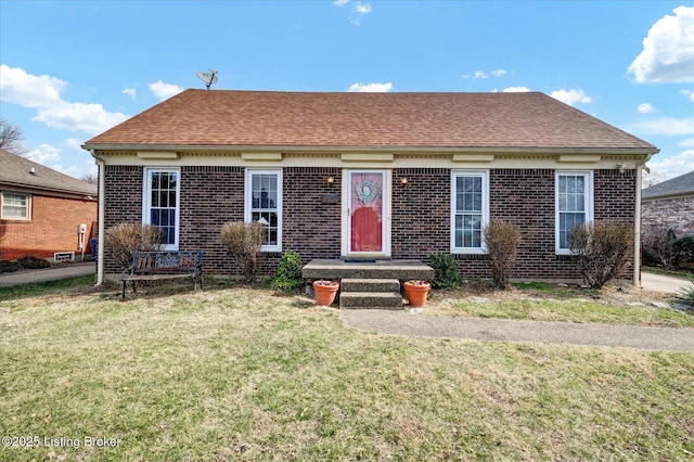 view of front of property featuring brick siding, a shingled roof, and a front lawn