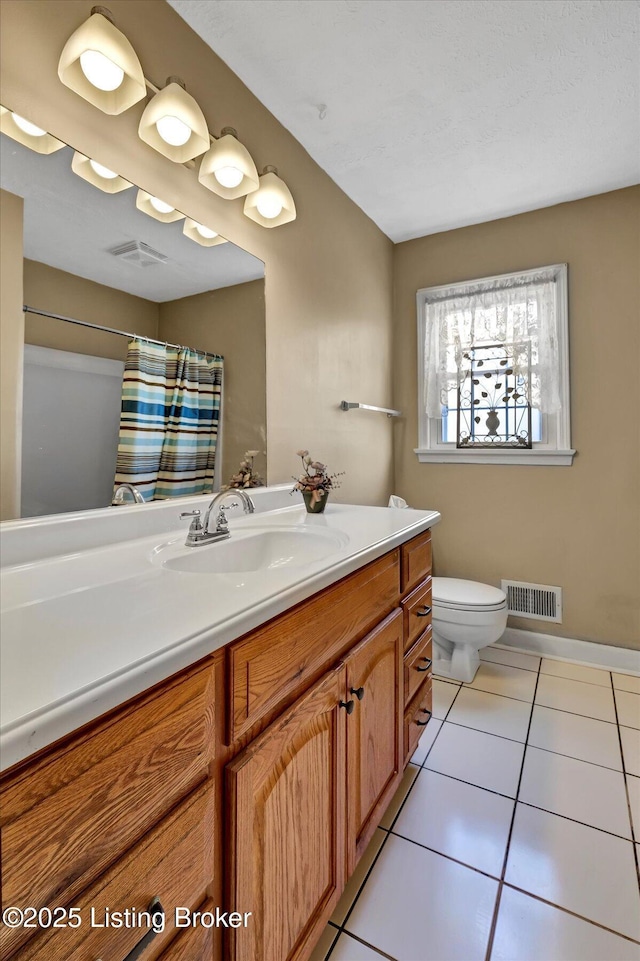 bathroom featuring tile patterned flooring, visible vents, toilet, and vanity