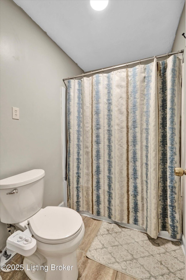 full bathroom with curtained shower and toilet