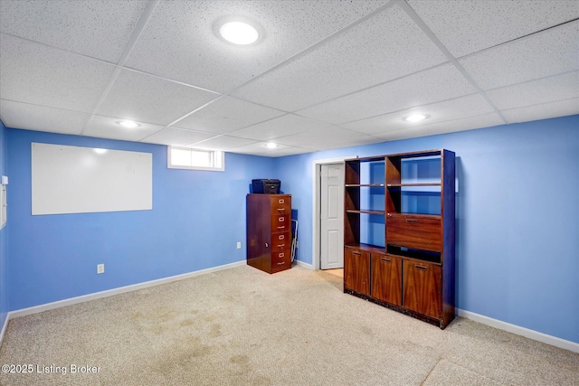 interior space with carpet flooring, a paneled ceiling, and baseboards