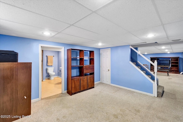 finished basement featuring a drop ceiling, recessed lighting, stairway, carpet flooring, and baseboards