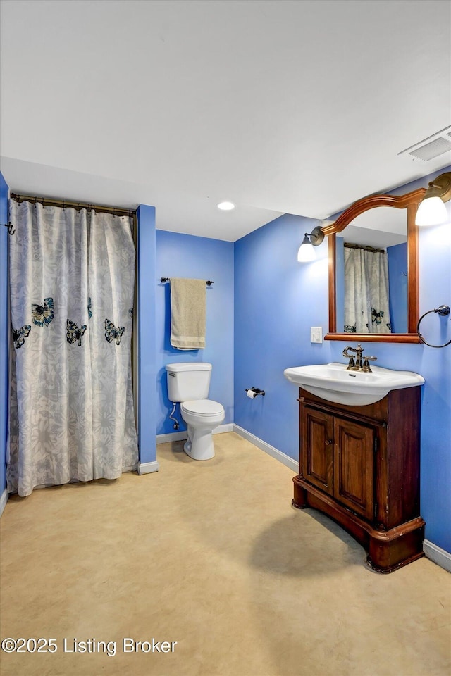 bathroom with baseboards, toilet, and vanity