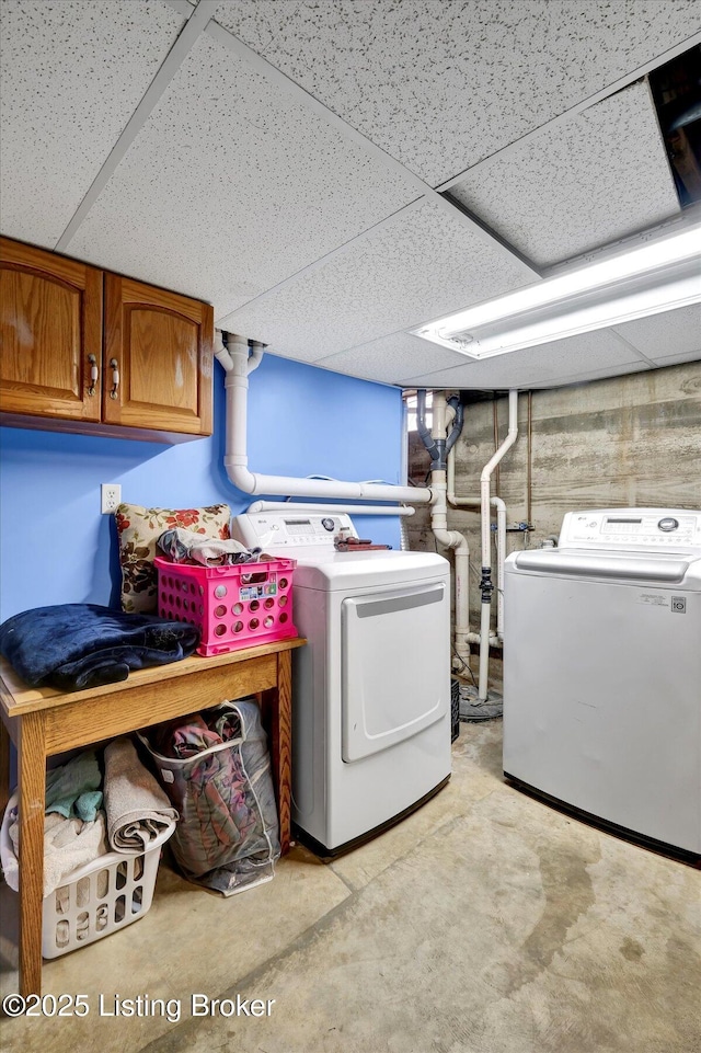 laundry room featuring washing machine and clothes dryer and cabinet space