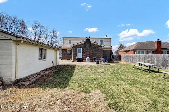 rear view of house featuring entry steps, a patio, a yard, and fence