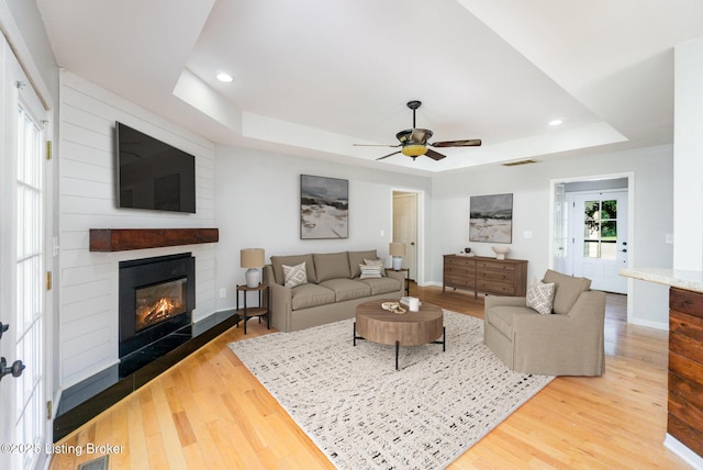 404 Persell Rd, Bedford, KY 40006 - living area with a tray ceiling, wood finished floors, a fireplace, a ceiling fan, and recessed lighting