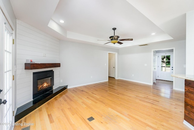 404 Persell Rd, Bedford, KY 40006 - unfurnished living room featuring a raised ceiling, light wood-style flooring, a fireplace, baseboards, and recessed lighting