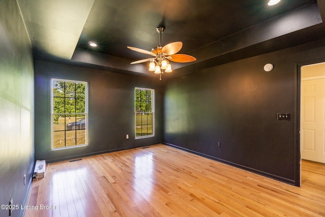 404 Persell Rd, Bedford, KY 40006 - unfurnished room featuring hardwood / wood-style floors, a ceiling fan, a tray ceiling, and a smoke detector