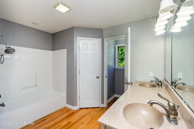 404 Persell Rd, Bedford, KY 40006 - full bath featuring double vanity, wood finished floors, washtub / shower combination, and baseboards