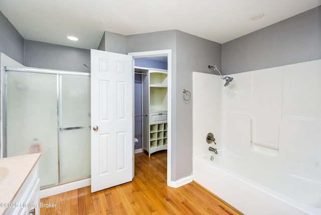 404 Persell Rd, Bedford, KY 40006 - full bathroom featuring wood finished floors, vanity, a walk in closet, recessed lighting, and washtub / shower combination