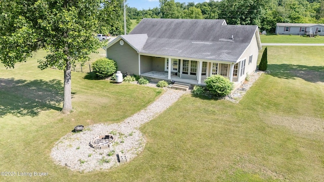 404 Persell Rd, Bedford, KY 40006 - view of front facade with a porch, roof with shingles, a front yard, driveway, and an outdoor fire pit