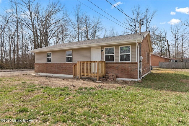 ranch-style home featuring a front yard, fence, and brick siding