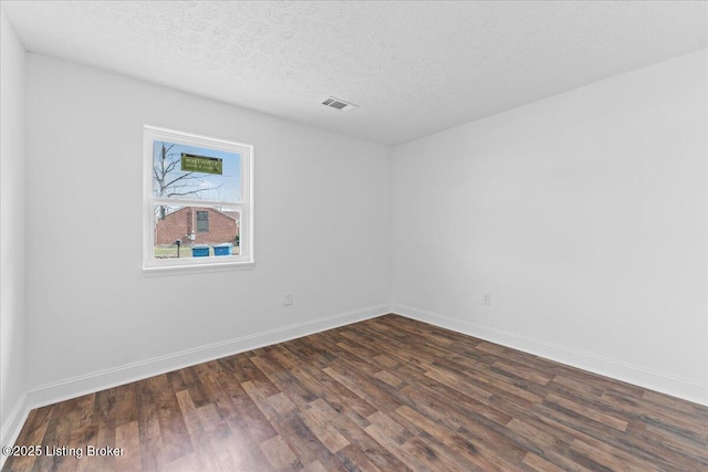 empty room featuring visible vents, a textured ceiling, baseboards, and dark wood-style flooring