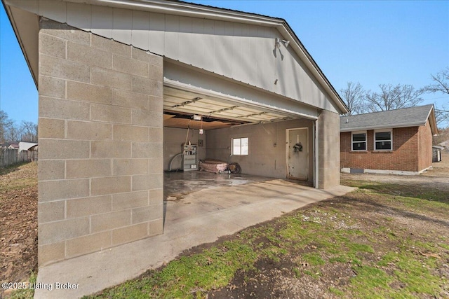 rear view of property featuring brick siding, a garage, driveway, and board and batten siding