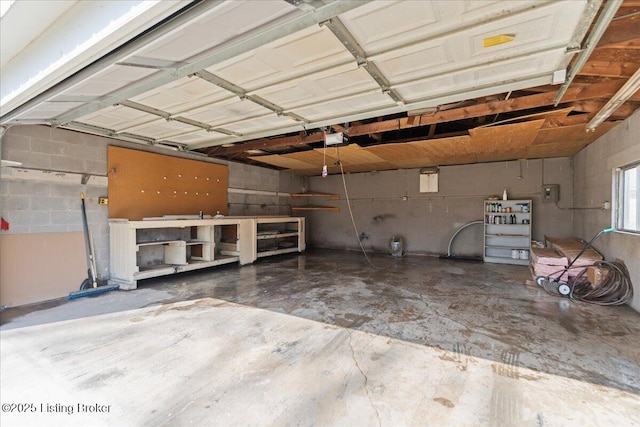 garage featuring concrete block wall and a garage door opener