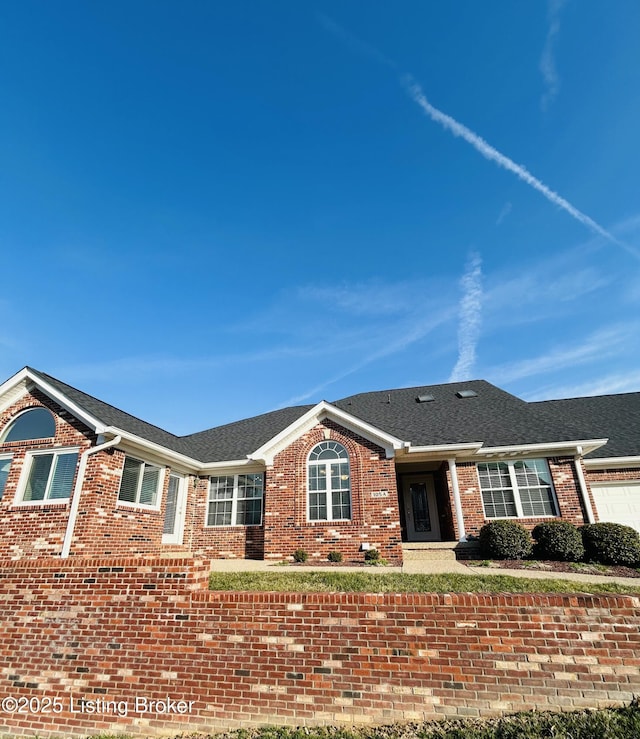 ranch-style home with an attached garage, brick siding, and a shingled roof