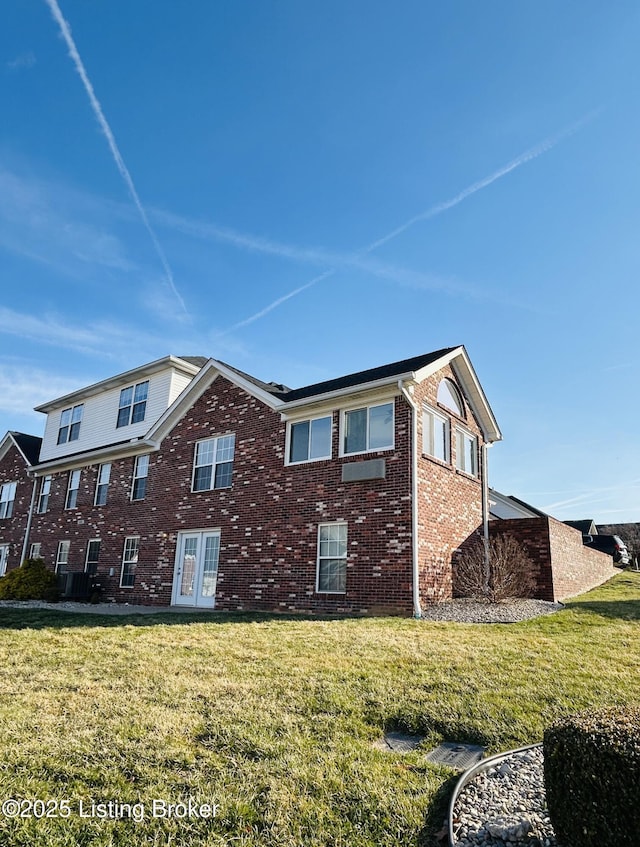 view of side of property with a lawn and brick siding