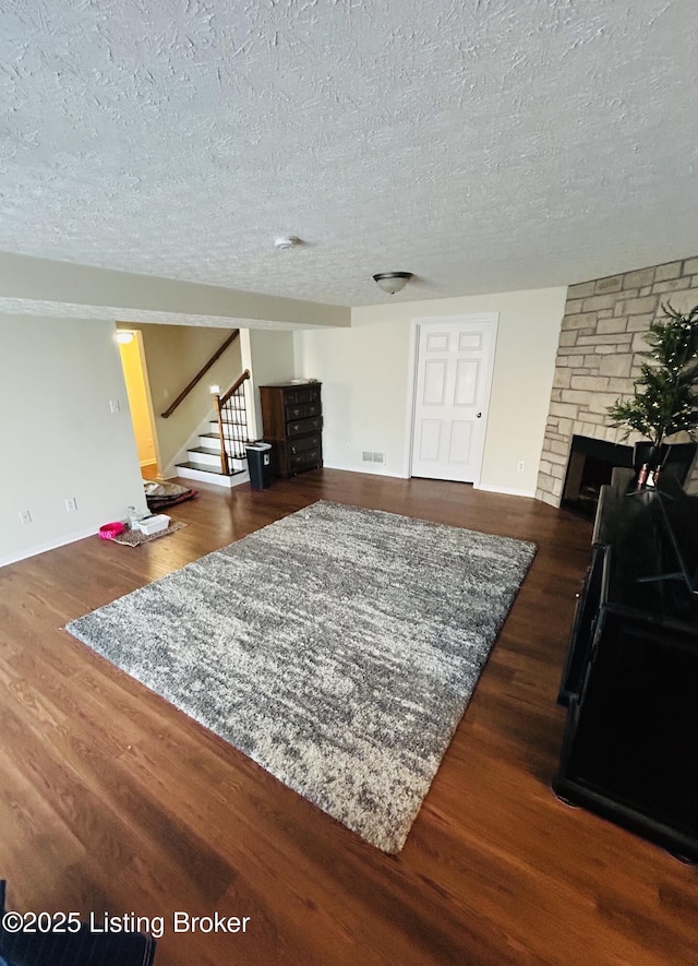 105-A Legacy Ct, Elizabethtown, KY 42701 - living area featuring stairs, a stone fireplace, wood finished floors, and a textured ceiling