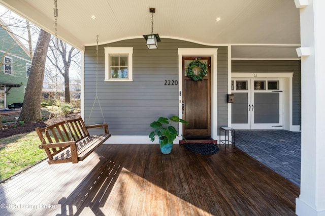 property entrance featuring a porch and french doors